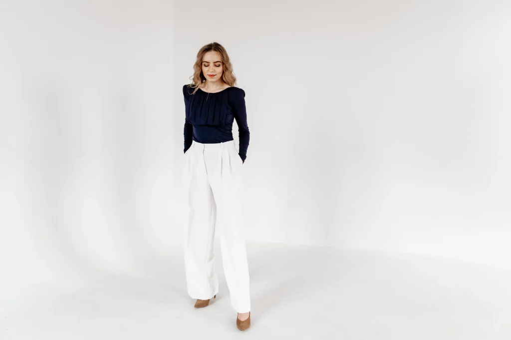 Woman in navy blue longsleeve and white pants
